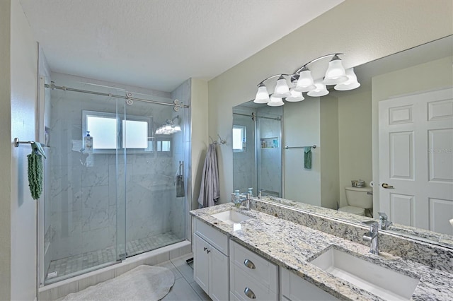 bathroom featuring toilet, tile patterned flooring, vanity, a textured ceiling, and a shower with shower door