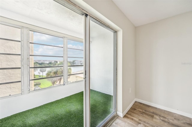 interior space with a water view, wood-type flooring, and plenty of natural light