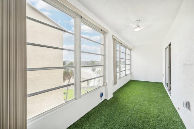 unfurnished sunroom with a healthy amount of sunlight and ceiling fan