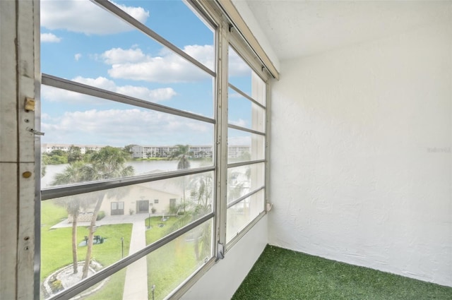 interior space with a water view and carpet flooring