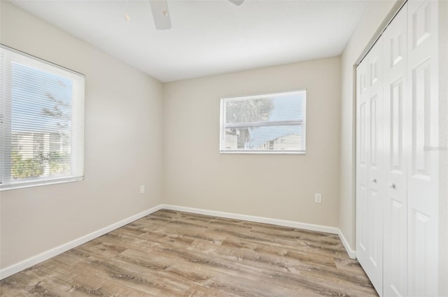 unfurnished bedroom featuring a closet, ceiling fan, and light hardwood / wood-style flooring