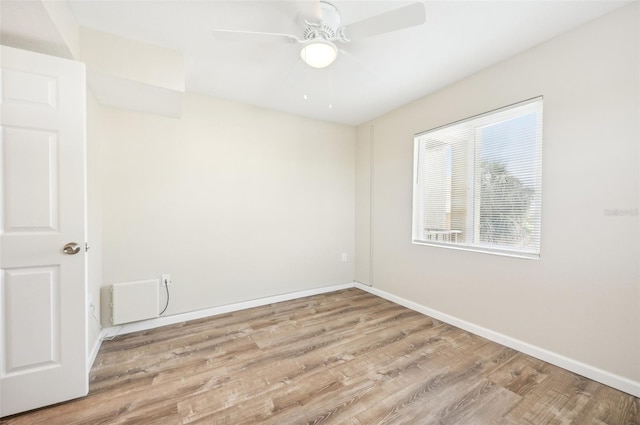 spare room with ceiling fan and light wood-type flooring