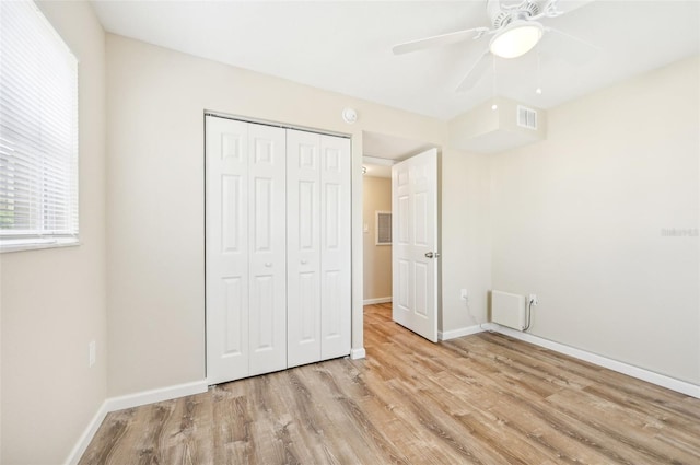 unfurnished bedroom featuring light hardwood / wood-style flooring, ceiling fan, and a closet