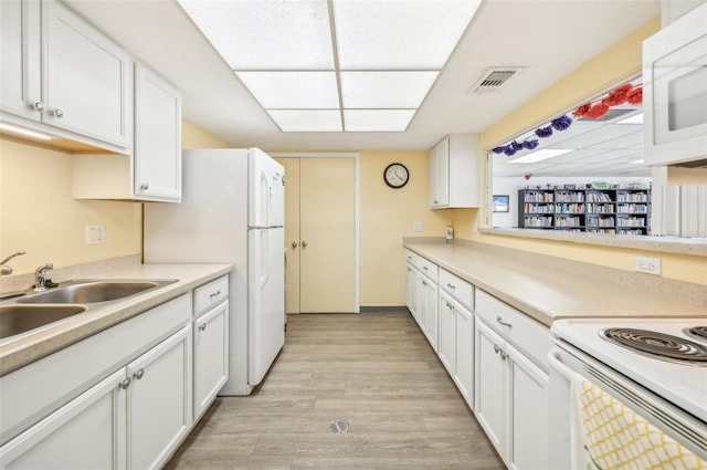 kitchen with light wood-type flooring, sink, white appliances, and white cabinets