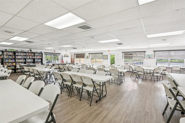 dining area with hardwood / wood-style flooring and a drop ceiling