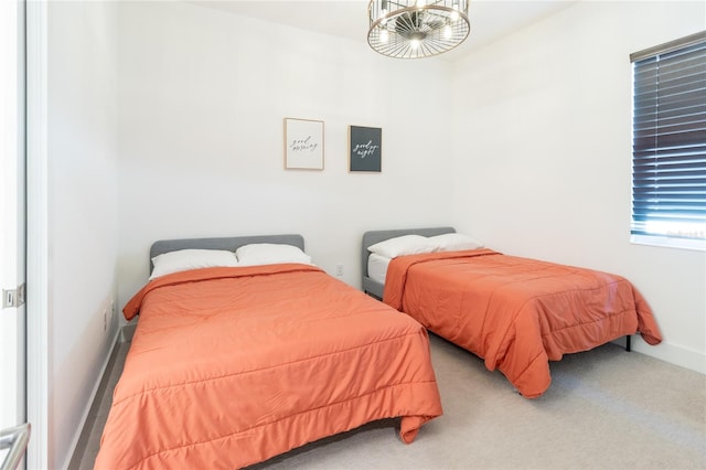 bedroom with a notable chandelier and carpet floors