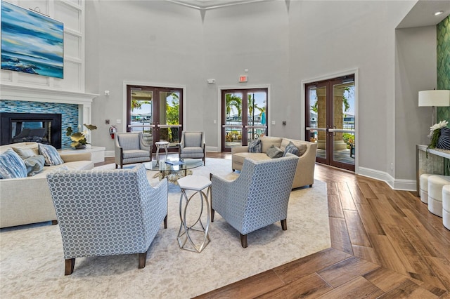 living room with a towering ceiling, wood-type flooring, and french doors