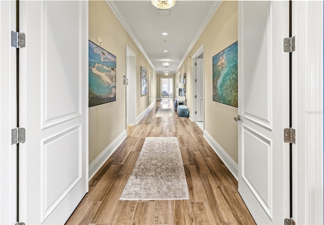 corridor featuring light hardwood / wood-style floors and ornamental molding