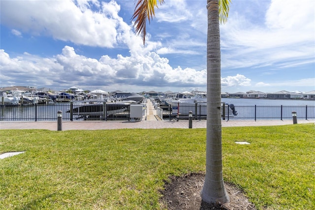 dock area with a water view and a lawn