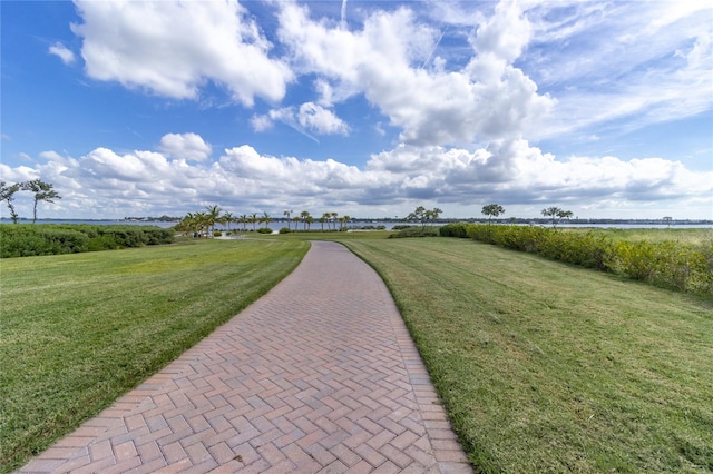 view of property's community with a water view and a yard