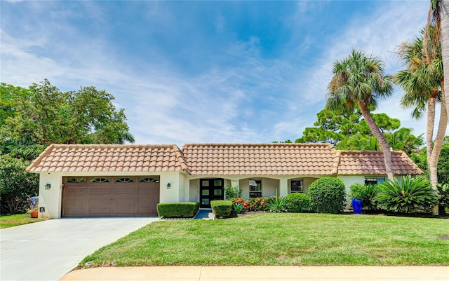 mediterranean / spanish-style house with a front yard and a garage