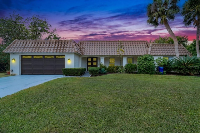 view of front facade with a garage and a yard