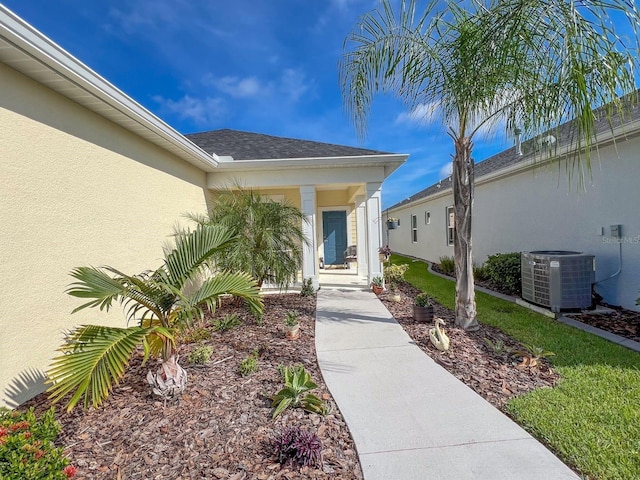 doorway to property with a yard and central AC