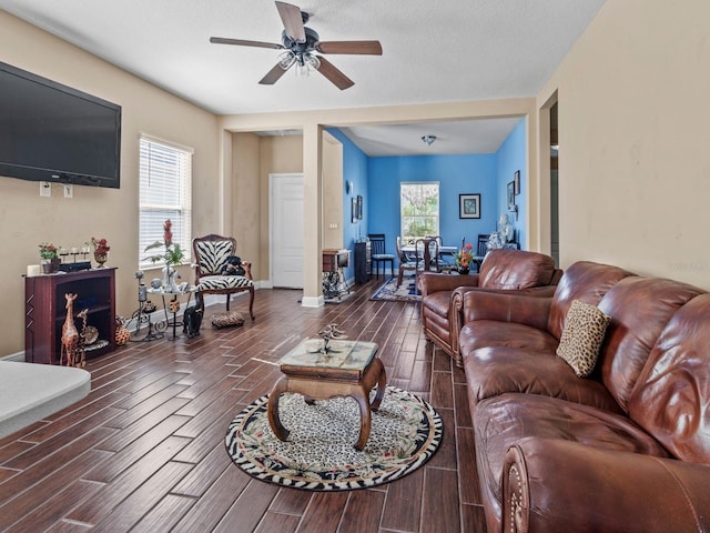 living room with dark wood-type flooring, ceiling fan, a textured ceiling, and a healthy amount of sunlight