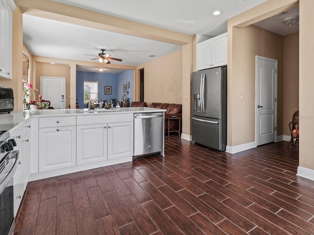 kitchen with appliances with stainless steel finishes, dark hardwood / wood-style flooring, and white cabinetry