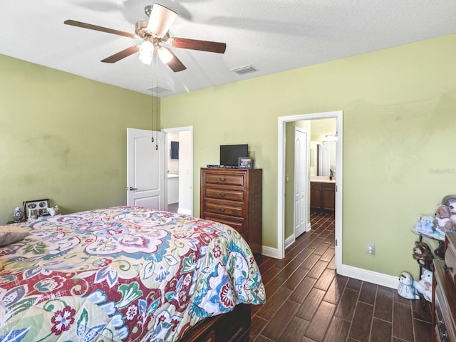 bedroom featuring ceiling fan, a textured ceiling, connected bathroom, and dark hardwood / wood-style flooring