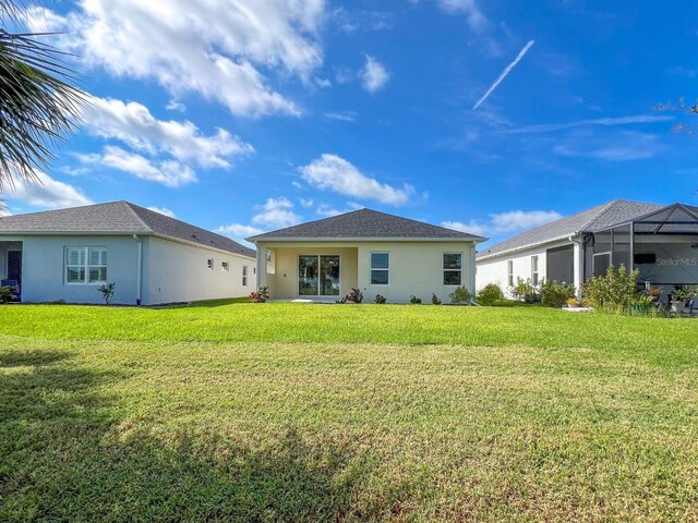 back of house featuring a yard and a lanai