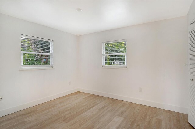 empty room with baseboards and light wood finished floors