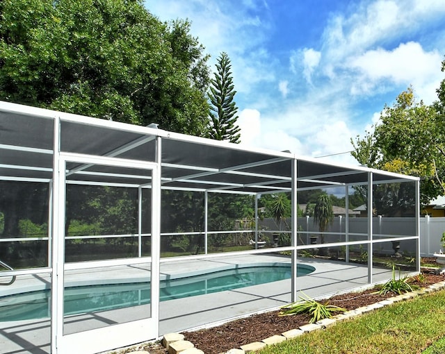 view of swimming pool featuring a patio, fence, a fenced in pool, and a lanai