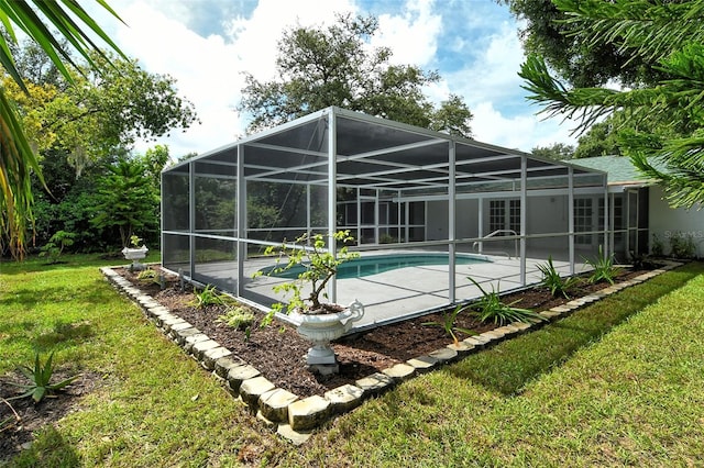 outdoor pool with glass enclosure, a lawn, and a patio area