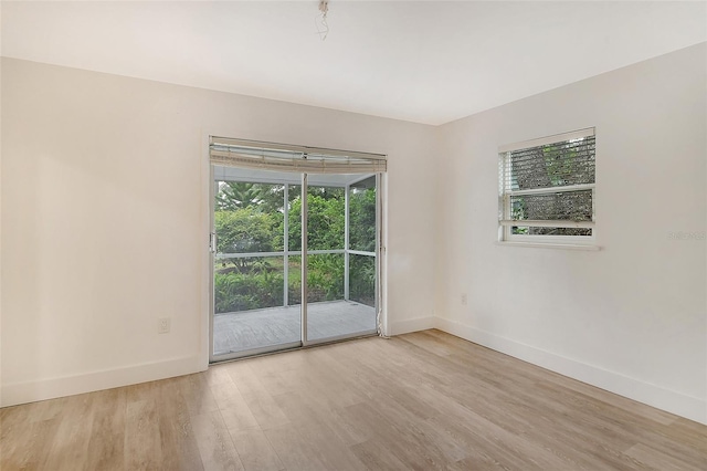 spare room with a wealth of natural light and light wood-type flooring