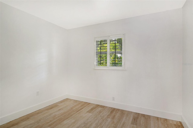 spare room featuring baseboards and light wood-style flooring