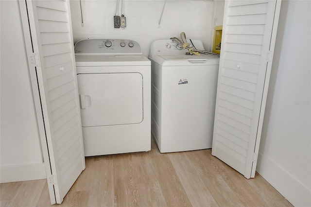 washroom with light hardwood / wood-style flooring and independent washer and dryer