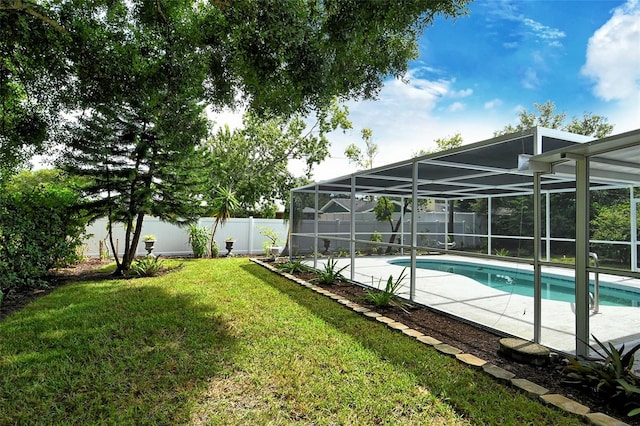 view of pool featuring glass enclosure, a patio area, and a yard