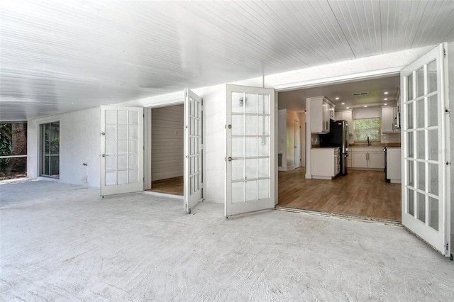 interior space featuring a healthy amount of sunlight, french doors, and sink