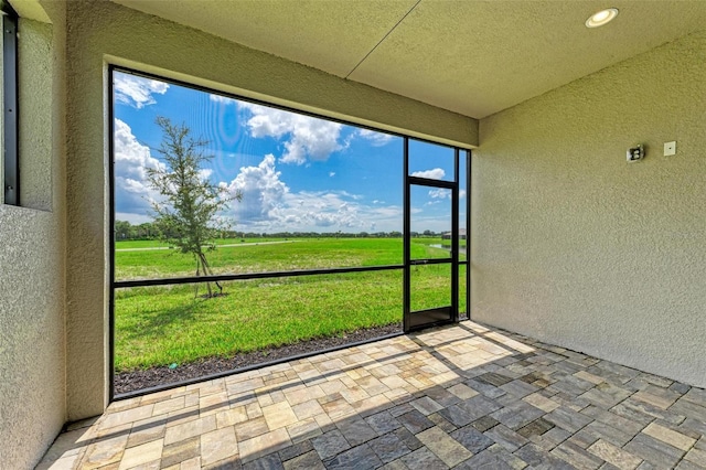 unfurnished sunroom with a rural view