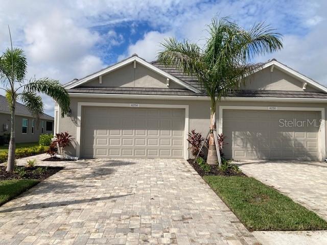 4254 Golden Creek Ter, Parrish, FL 34219 - view of front of property with decorative driveway, stucco siding, and an attached garage