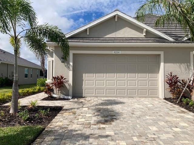 4254 Golden Creek Ter, Parrish, FL 34219 - view of front of property featuring stucco siding, a garage, and decorative driveway