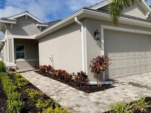 4254 Golden Creek Ter, Parrish, FL 34219 - view of home's exterior with an attached garage, stucco siding, and driveway