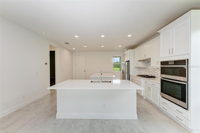 4254 Golden Creek Ter, Parrish, FL 34219 - kitchen with appliances with stainless steel finishes, a sink, an island with sink, under cabinet range hood, and white cabinets