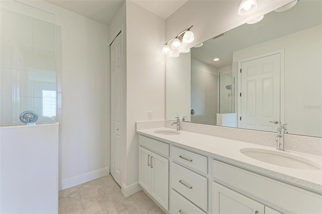 bathroom with vanity, tiled shower, and tile patterned floors