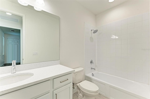 full bathroom featuring tiled shower / bath, vanity, and toilet