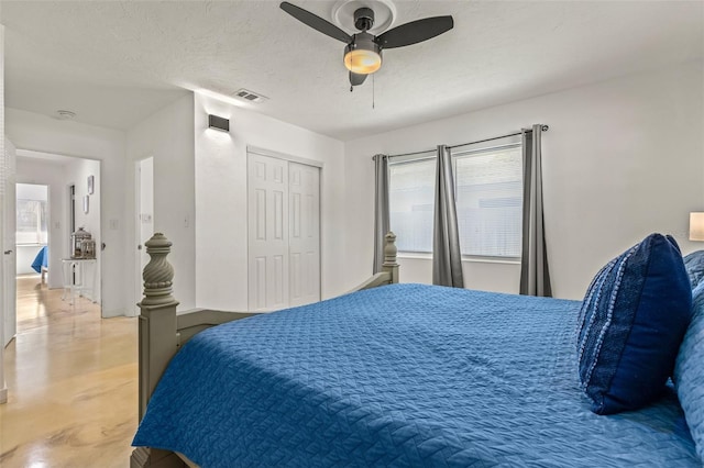 bedroom with a textured ceiling, ceiling fan, and a closet