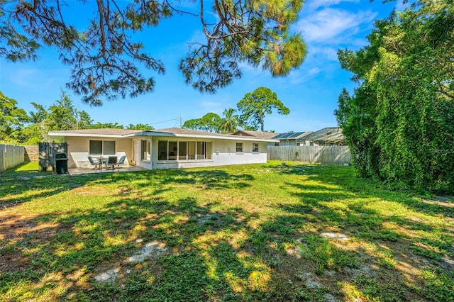 back of house with a lawn and a patio area