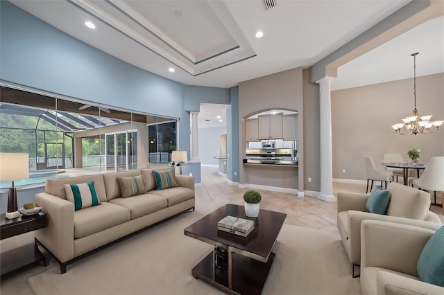 living room with light tile patterned floors, a chandelier, and decorative columns