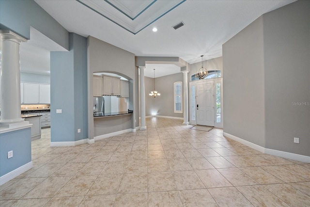 interior space with decorative columns, light tile patterned floors, and a chandelier