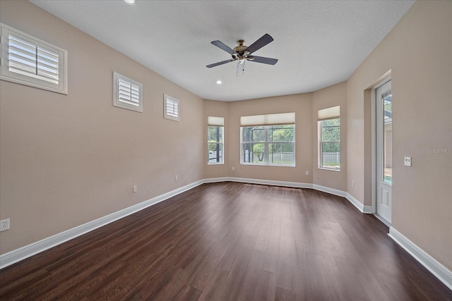 empty room with ceiling fan, dark hardwood / wood-style flooring, and a textured ceiling