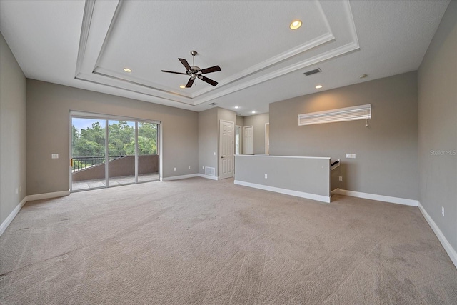 unfurnished room featuring ceiling fan, light colored carpet, and a raised ceiling