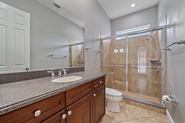 bathroom featuring tile patterned flooring, vanity, toilet, and an enclosed shower