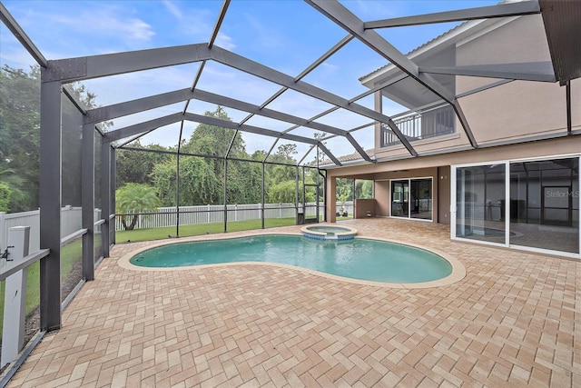 view of pool with glass enclosure, a patio area, and an in ground hot tub