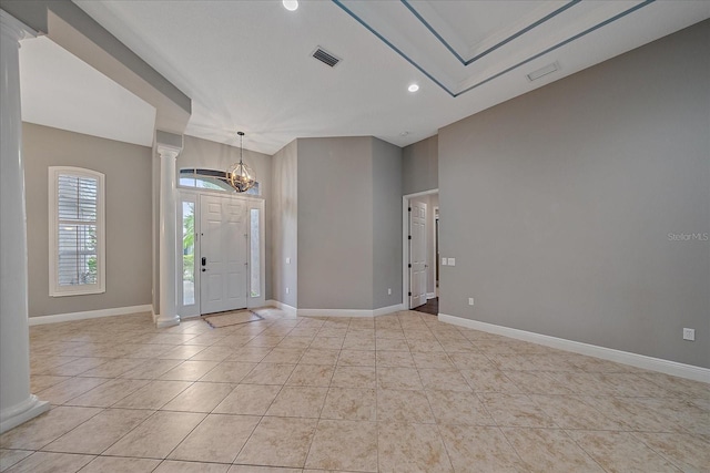 foyer entrance with light tile patterned flooring and decorative columns