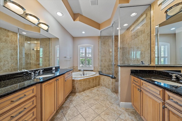 bathroom featuring tile patterned flooring, shower with separate bathtub, and vanity