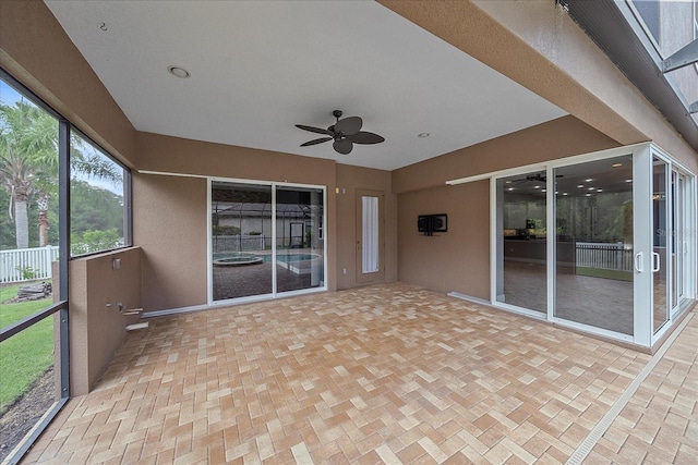 unfurnished sunroom featuring ceiling fan