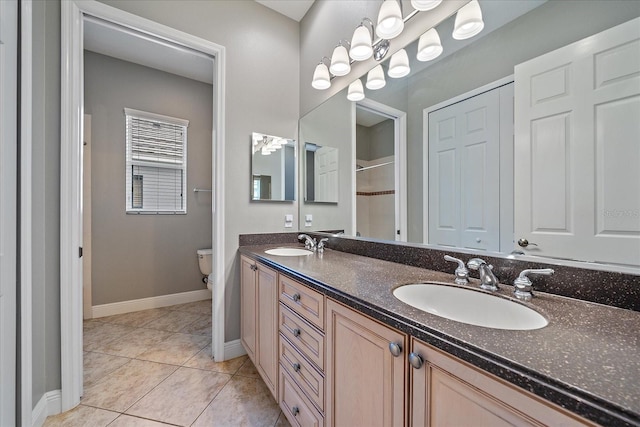 bathroom with tile patterned flooring, toilet, and vanity