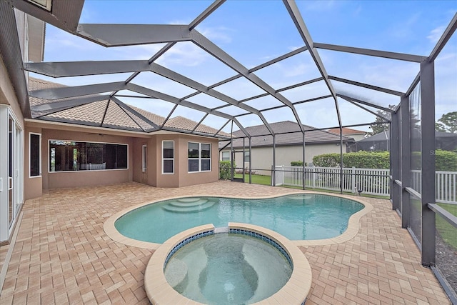 view of swimming pool with glass enclosure, a patio area, and an in ground hot tub