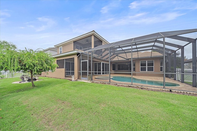 back of house featuring a patio area, a fenced in pool, a yard, and a lanai